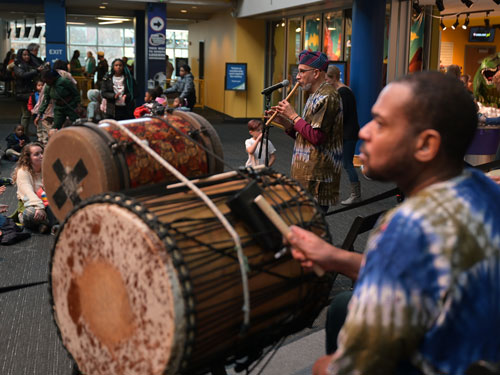 Griot Drum Ensemble in front of a crowd at The Children's Museum.